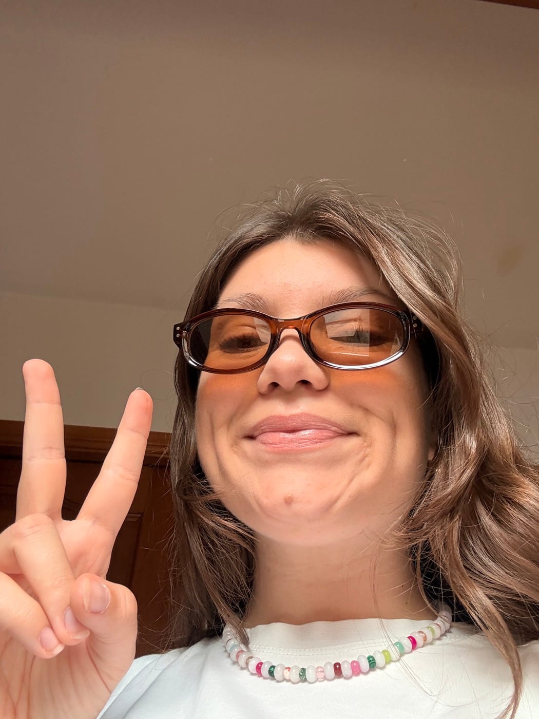 Lunettes brunes, peace et collier de perles multicolore